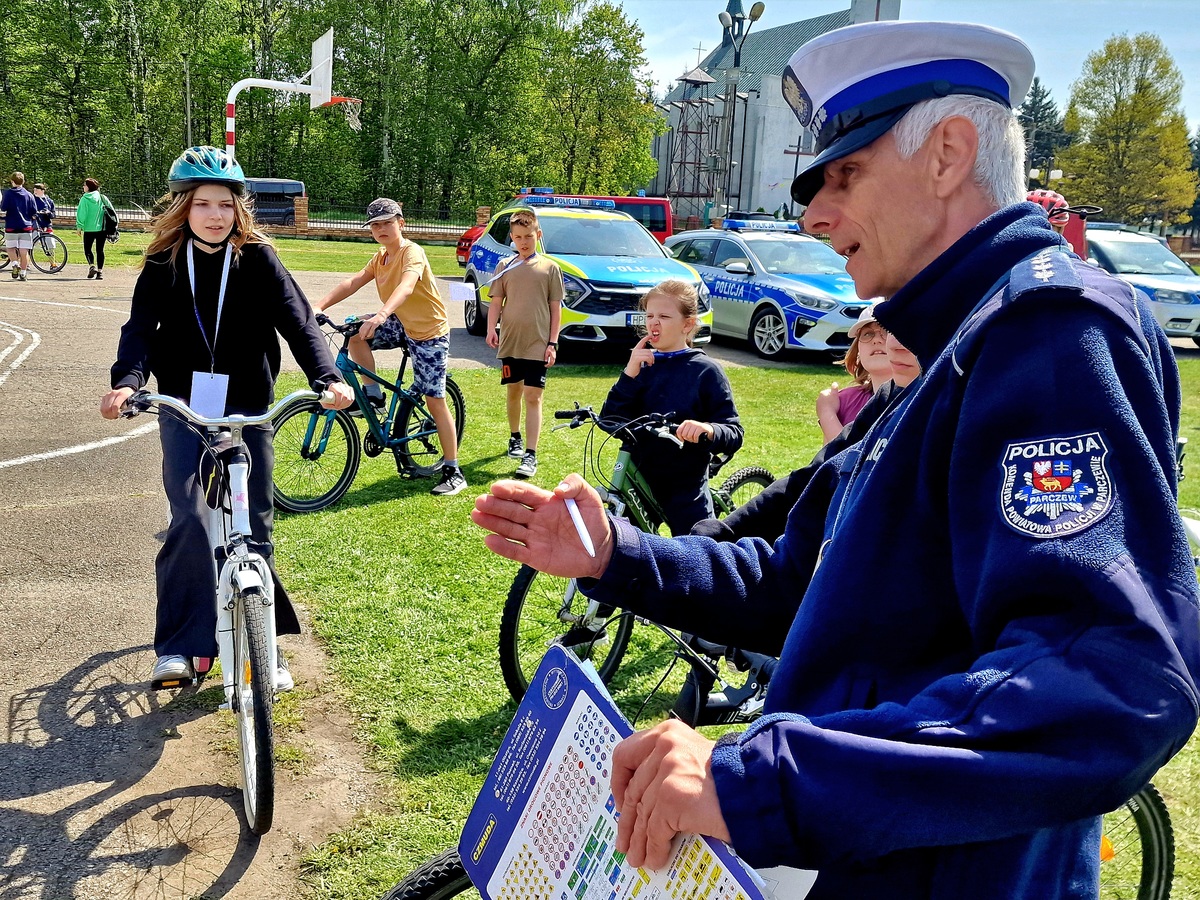 policjant i 2 uczniów na rowerach