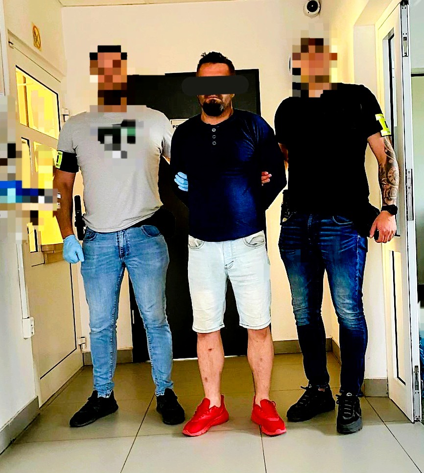 zatrzymany doprowadzany przez policjatów kryminalnych