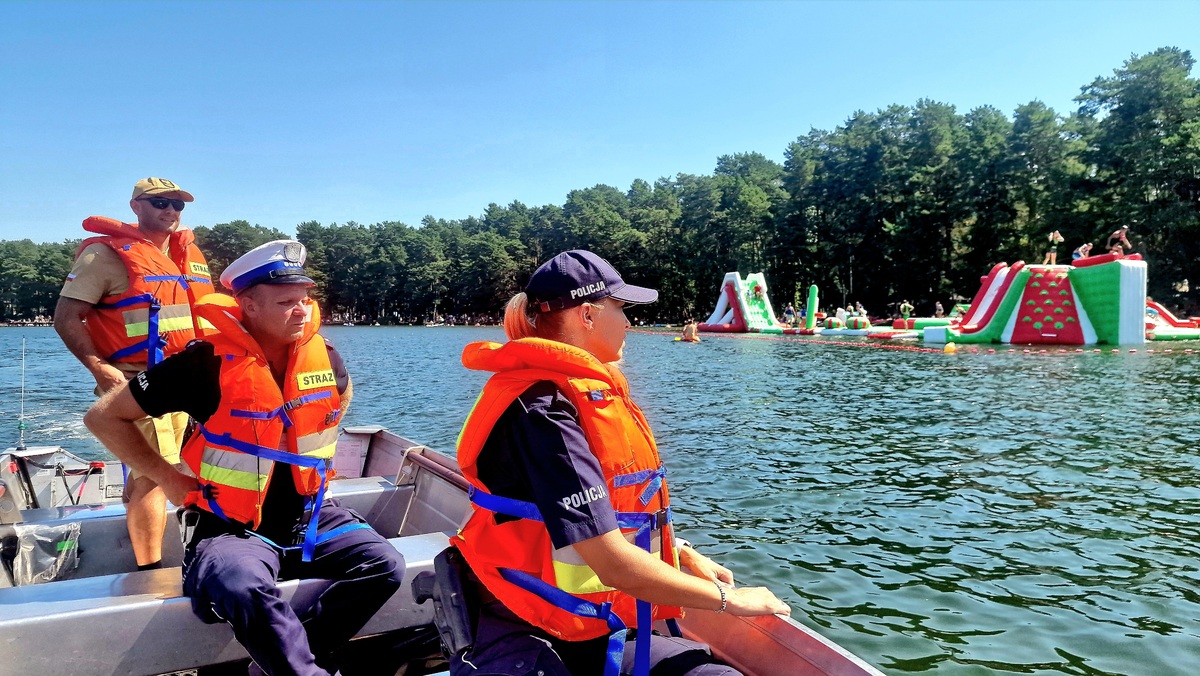 policjanci i strażacy na łodzi motorowej