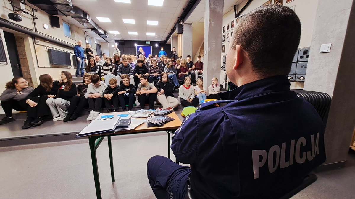 policjant na auli przed grupa uczniów