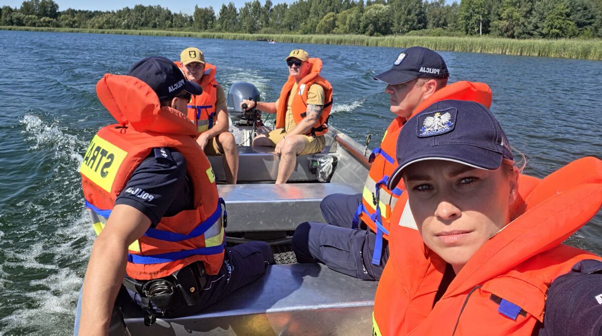 policjanci i strażacy na łodzi