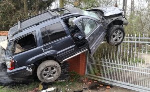 Terenowy samochód zawisł na ogrodzeniu. Obok zniszczone ogrodzenie.