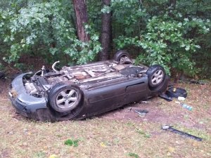 Pojazd marki Audi leżący na dachu w przydrożnym rowie