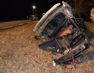 Rozbity pojazd marki Mercedes leżący na dachu w przydrożnym rowie