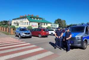 policjanci prewencji w rejonie szkoły podstawowej policyjnym oznakowanym busem