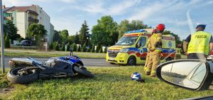 wypadek z udziałem motocyklisty, pojazd suzuki leżący bokiem na pasie zieleni