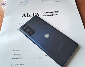 telefon komórkowy leżacy na teczce z napisem akta