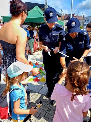 policjantki rozdające odblaski i lizaki najmłodszym