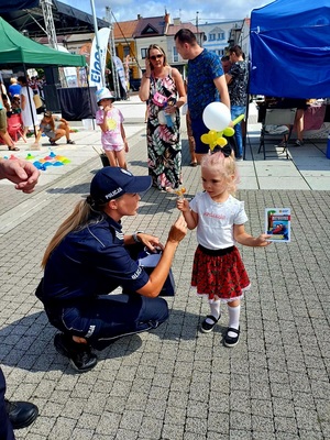 policjantka dająca małej dziewczynce lizaka