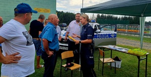 policjanta z urządzeniem alcoblow tłumacząca zainteresowanym zasadę jego działania