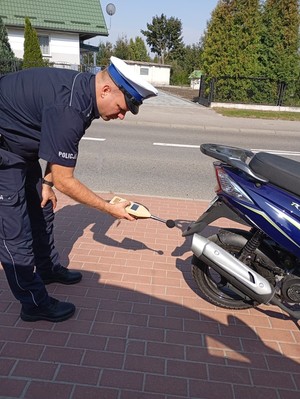 policjant kontroluje sonometr poziom hałasu w motocyklu