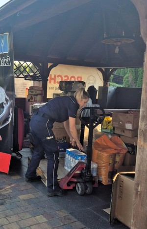 policjanta nosząca paczki ze zbiórki