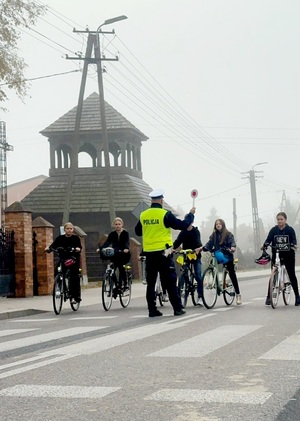 policjant ruchu drogowego zatrzymujący uczniów jadących rowerami