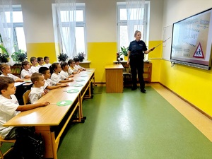 policjantka w sali wykładowej z uczniami