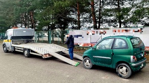 czterokołowiek lekki koloru zielonego podczas załadunku na lawetę