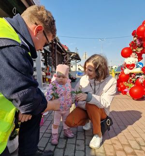 policjant wreczajacy małej dziewczynce kwiaty