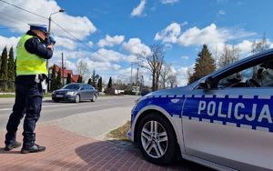 policjant w trakcie pomiaru prędkości pojazdów