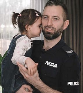 policjant z dziewczynka na rekach
