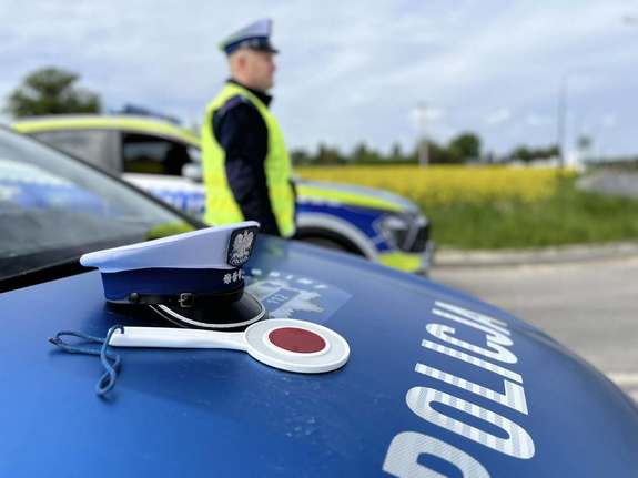 oznakowany radiowóz i policjant w tle