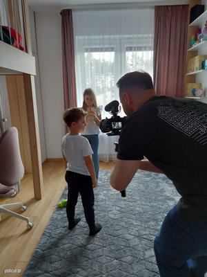 męzczyzna nagrywający dzieci przy pomocy kamery