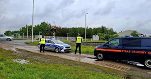 policjant i funkcjonariusz straży ochrony kolei w rejonie przejazdu kolejowego