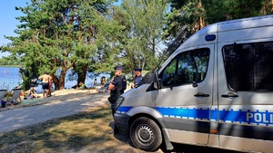 policjanci przed radiowozem nad jeziorem