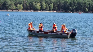 policjanci i strażacy na łodzi motorowej
