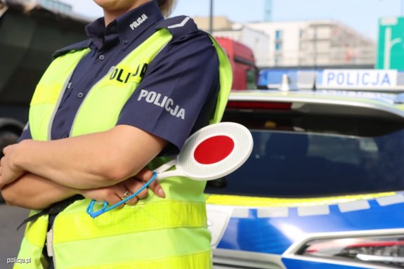 policjantka z tarczą do zatrzymywania pojazdów