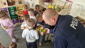 policjant wręczający dzieciom odblaski