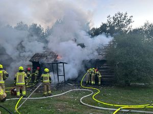 strażacy w trakcie akcji ratowniczo - gaśniczej palącego się domu