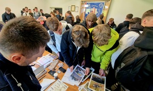 uczniowie oglądający zdjęcia technika kryminalistyki