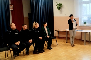 policjanci siedzący przodem do grupy uczniów na krzesłach