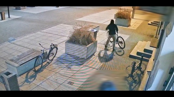 Mężczyzna kradnie rower.