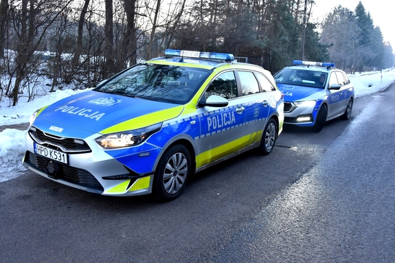 dwa radiowozy na drodze w porze zimowej