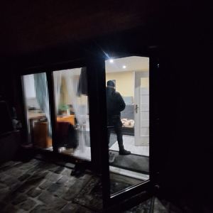 widok przez otwarte okno do wnętrza mieszkania nocą