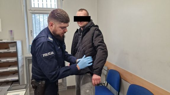 poszukiwany mężczyzna sprawdzany przez umundurowanego policjanta