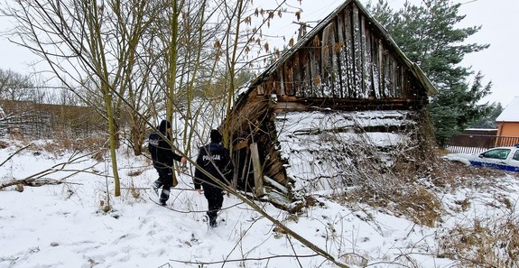 policjanci idący do pustostanu domu