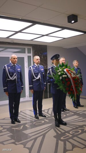 policjanci w gabardynach z kwiatami