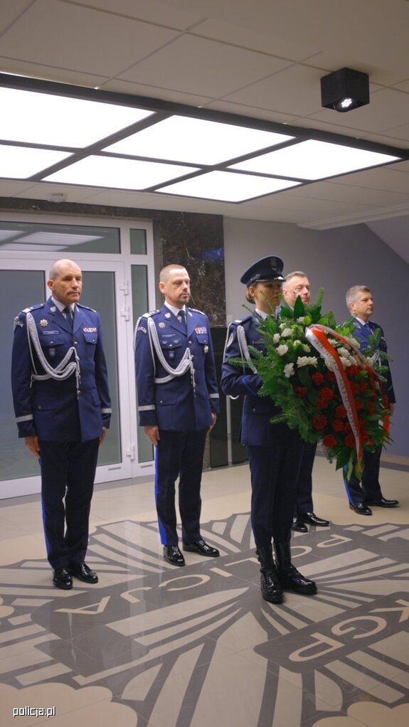 policjanci w gabardynach z kwiatami