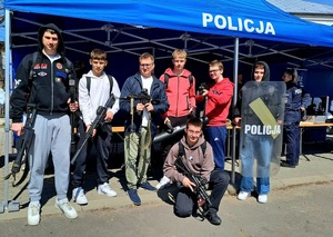 chłopcy trzymający w rękach rozładowana broń wraz z opiekunem