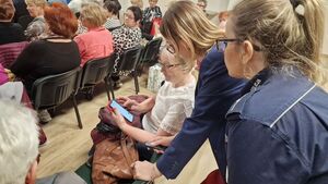 policjantki spogladające na telefon seniora