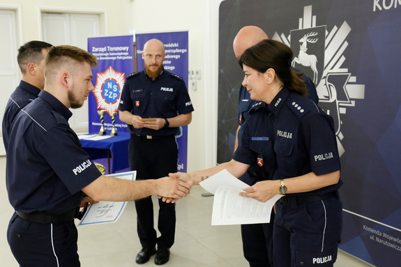 policjanci podczas otrzymywania pucharu z rąk komendanta