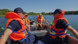 policjanci i strażacy na łodzi