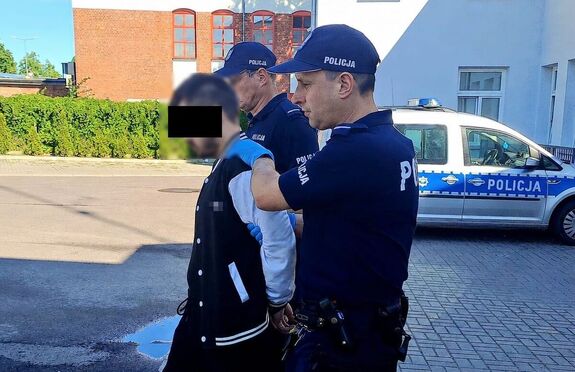 Umundurowani policjanci wyprowadzają z Komendy Powiatowej Policji w Parczewie zatrzymanego mężczyznę.