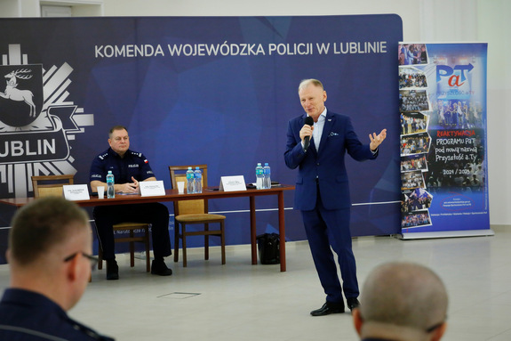 policjant za biurkiem i mężczyzna w garniturze