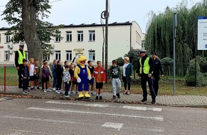 policjanci i dzieci przechodzący przez przejscie dla pieszych