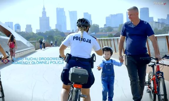 mężczyzna  i dziecko oraz policjant na rowerze