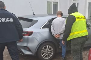 policjanci prowadzą zatrzymanego mężczyznę